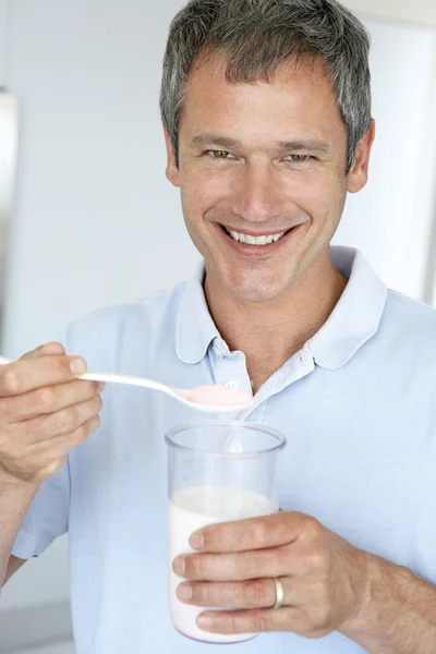Hombre de mediana edad sosteniendo suplementos dietéticos — Foto de Stock