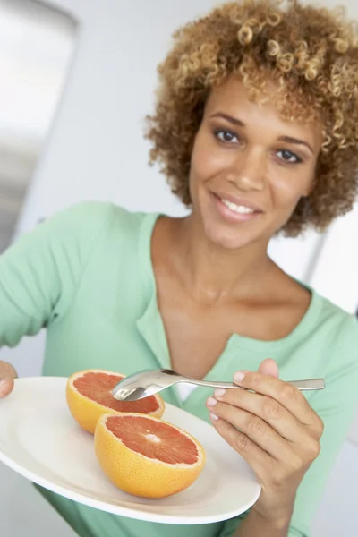 中旬成年女人吃新鲜葡萄柚 — 图库照片