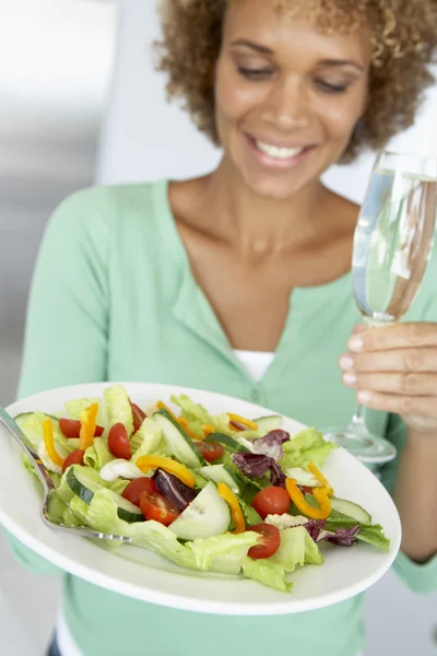中旬成年女性持有一个酒杯和新鲜的沙拉 — 图库照片