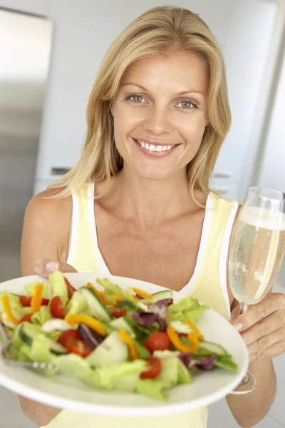 ワイン グラスや新鮮なサラダを保持している 代の女性 — ストック写真