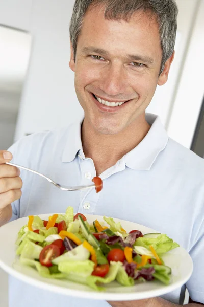 Uomo di mezza età che mangia un'insalata sana — Foto Stock