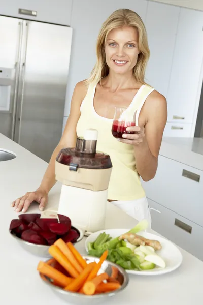 中期的成年女性 使新鲜的蔬菜汁 — 图库照片
