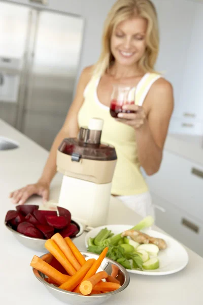 Mujer adulta media haciendo jugo de verduras frescas —  Fotos de Stock