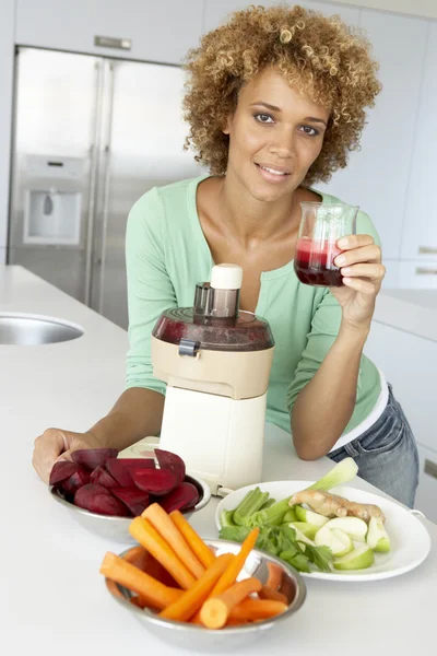 Mulher adulta média fazendo suco de legumes frescos — Fotografia de Stock