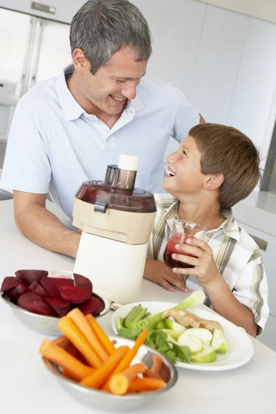 Far och son att göra färsk grönsaksjuice — Stockfoto