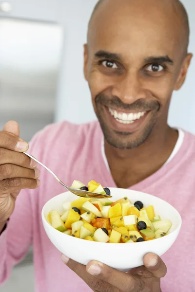 Мужчина среднего возраста ест свежий фруктовый салат — стоковое фото