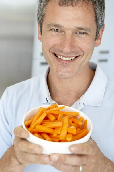 Uomo di mezza età che tiene una ciotola di carote — Foto Stock