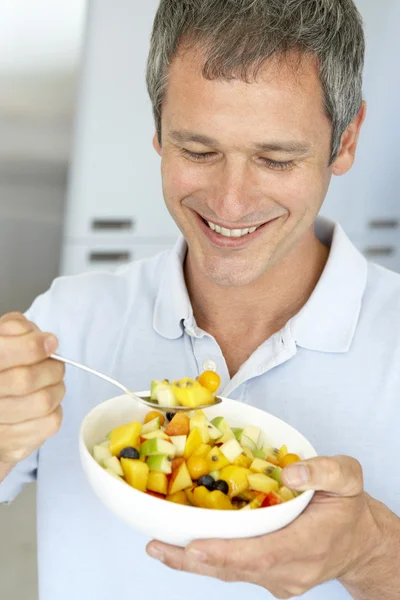 フレッシュフルーツサラダを食べる中年男性 — ストック写真