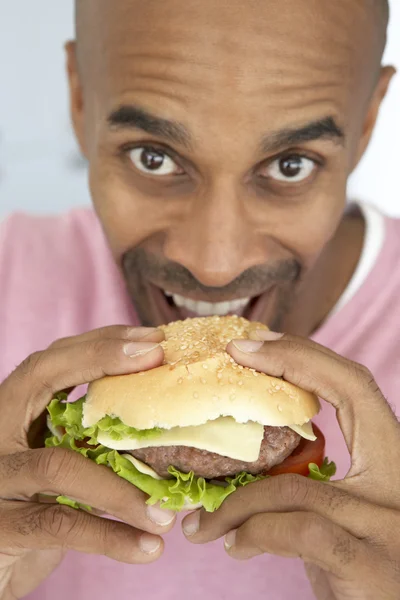 Mellersta åldern man äter en hamburgare — Stockfoto