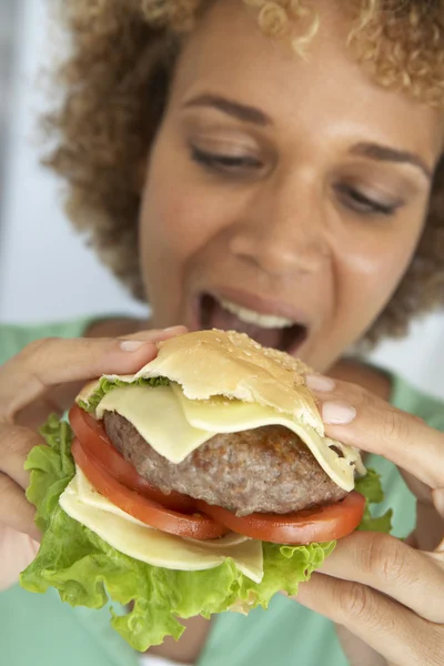 中期的成年女性 吃一个汉堡 — 图库照片