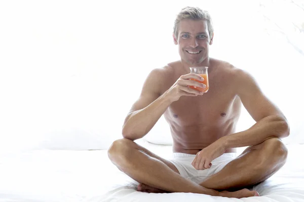 Mitte Erwachsener Mann Sitzt Auf Bett Und Trinkt — Stockfoto
