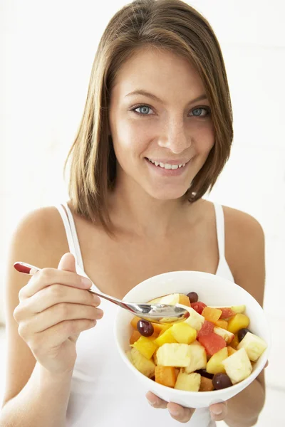 Genç bir kadın taze meyve salatası yiyor. — Stok fotoğraf