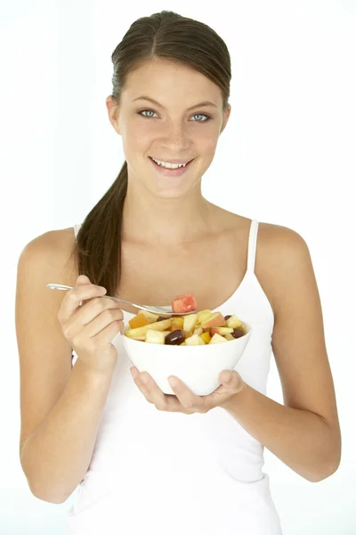 Ung kvinna äter färsk fruktsallad — Stockfoto