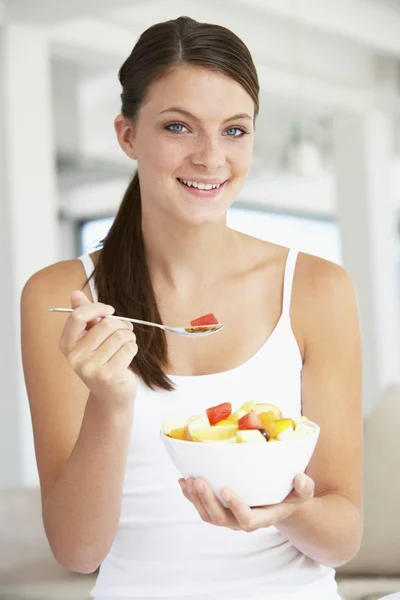 Mujer joven comiendo ensalada de frutas frescas —  Fotos de Stock