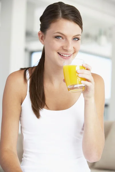 오렌지 주스 한 잔을 마시는 젊은 여자 — 스톡 사진