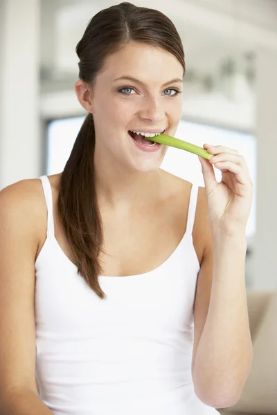 Jovem mulher comendo aipo varas — Fotografia de Stock