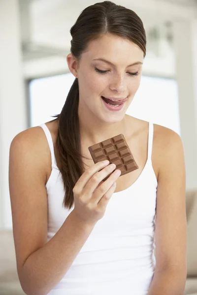 Jeune femme mangeant du chocolat — Photo