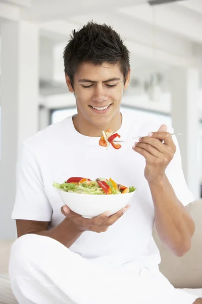 Junger Mann isst einen Salat — Stockfoto
