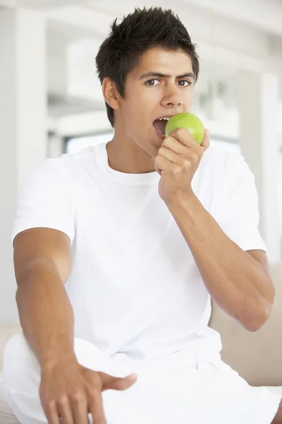 Giovane che mangia una mela verde — Foto Stock