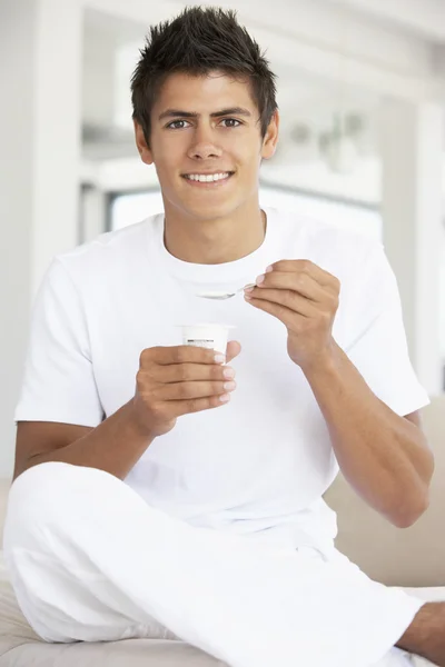 Mladý muž jíst jogurt — Stock fotografie