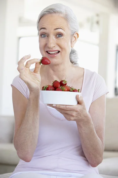 Mulher Sênior Comendo uma tigela de morangos — Fotografia de Stock