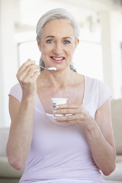 ヨーグルトを食べる年配の女性 — ストック写真
