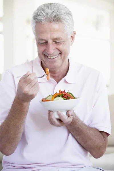 Среднего возраста человек ест салат — стоковое фото