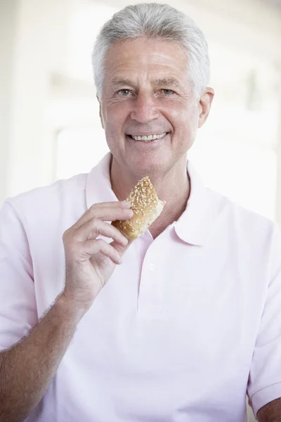 Среднего Возраста Человек Ест Коричневый Хлеб Ролл — стоковое фото