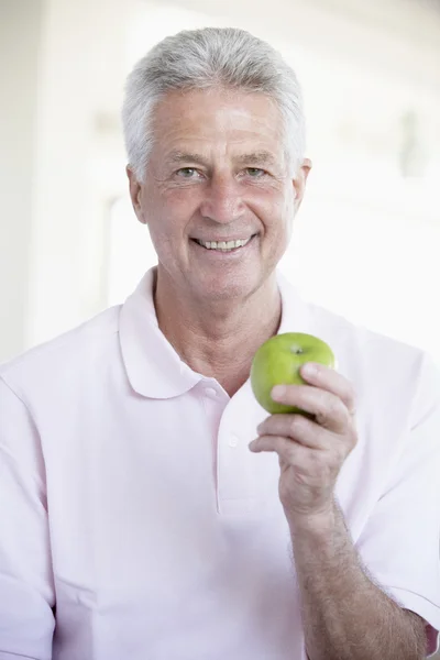Homem de meia-idade comendo maçã verde — Fotografia de Stock