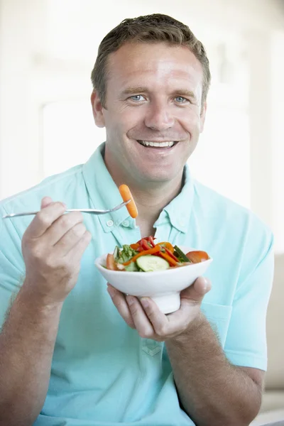 Mitte erwachsener Mann isst einen Salat — Stockfoto