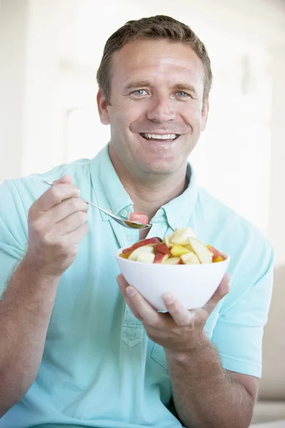Homem adulto médio comendo salada de frutas frescas — Fotografia de Stock