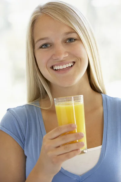 Menina adolescente bebendo um copo de suco de laranja — Fotografia de Stock