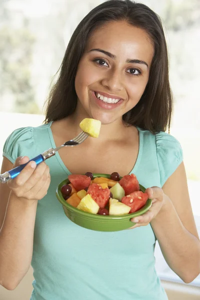 Menina adolescente comendo salada de frutas frescas — Fotografia de Stock