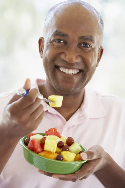 Homem de meia-idade comendo salada de frutas frescas — Fotografia de Stock