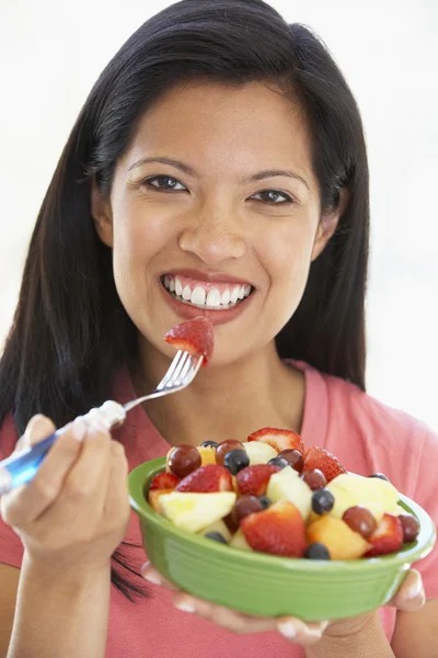 Połowie dorosła kobieta jedzenie sałatki ze świeżych owoców — Zdjęcie stockowe