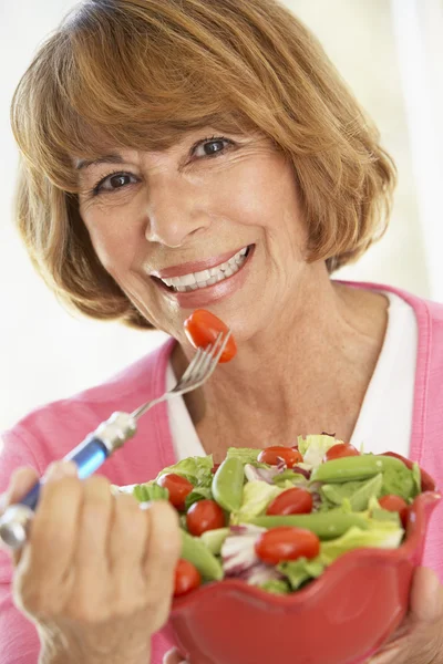 Mulher de meia-idade comendo uma salada verde fresca — Fotografia de Stock