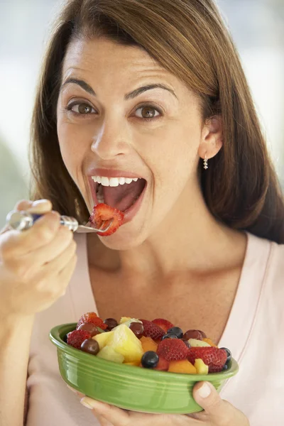 Mujer adulta medio comiendo una ensalada de frutas frescas —  Fotos de Stock