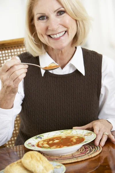 Seniorin trinkt Suppe — Stockfoto