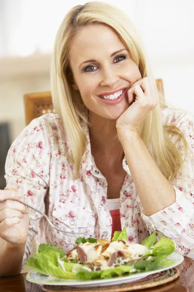 Μέσα του την ενήλικη γυναίκα τρώει ένα υγιές γεύμα, χαμογελά στη φωτογραφική μηχανή — Φωτογραφία Αρχείου