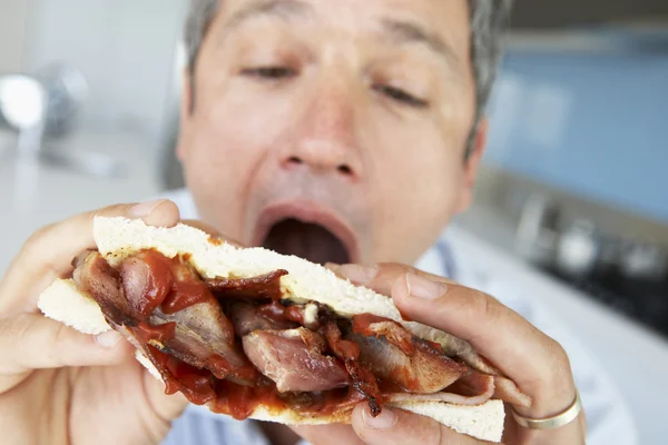 Middelste Leeftijd Man Eten Een Broodje Bacon — Stockfoto