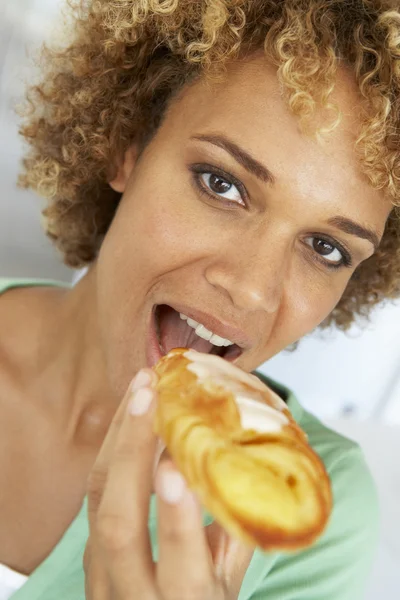 Mulher adulta média comendo uma pastelaria — Fotografia de Stock