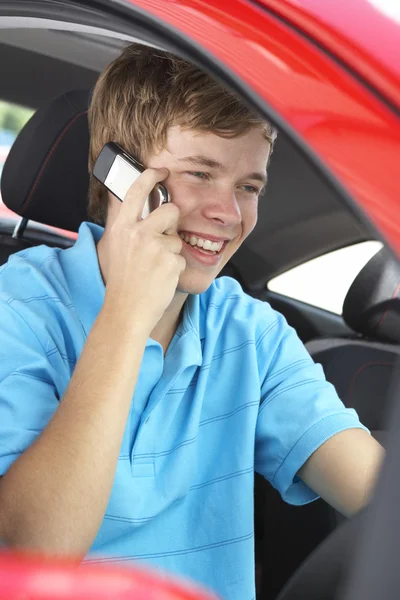 Tonårspojke som sitter i bilen, och talar i mobiltelefon — Stockfoto