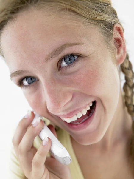 Tizenéves lány mosolyogva, és beszél a mobiltelefon portréja — Stock Fotó