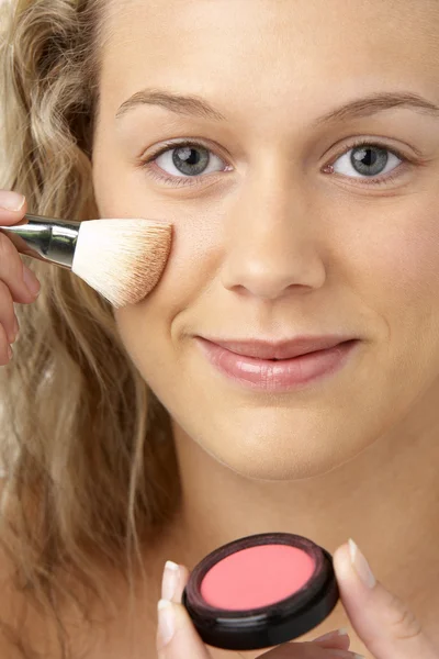 Mujer joven que aplica maquillaje — Foto de Stock