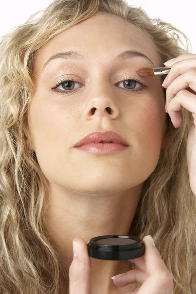 Jonge vrouw die make-up aanbrengt — Stockfoto