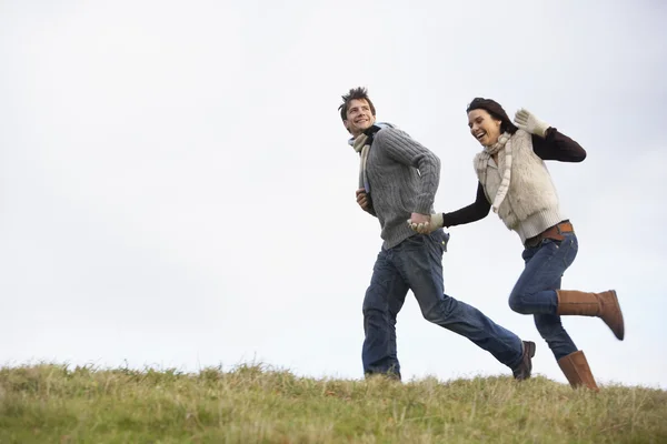Casal segurando as mãos e correndo no parque — Fotografia de Stock