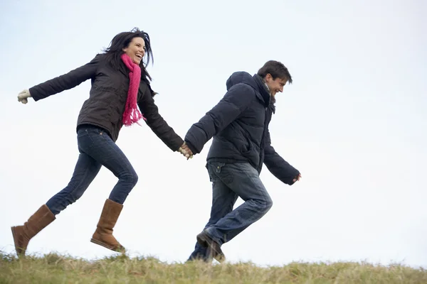 Casal segurando as mãos e correndo no parque — Fotografia de Stock