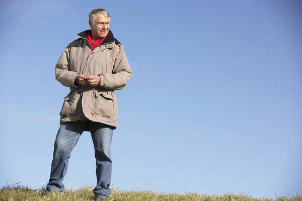 Starší muž, který stojí v parku — Stock fotografie