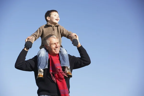 Дедушка носит внука на плечах — стоковое фото