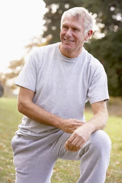 Портрет старшої людини на колінах в парку — стокове фото